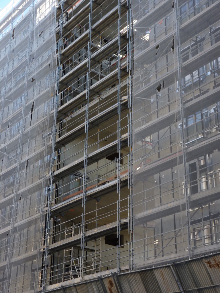 Pose des barres de fixation du bardage à l'intérieur de la faille entre les bâtiments B et C